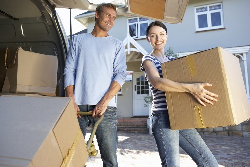 Professional movers carrying a sofa through a Battersea property